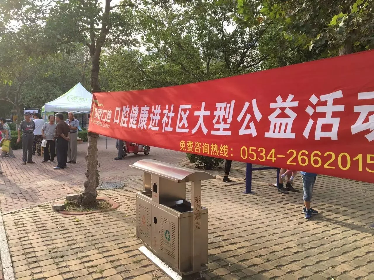 社区广场口腔健康公益活动横幅和服务点。