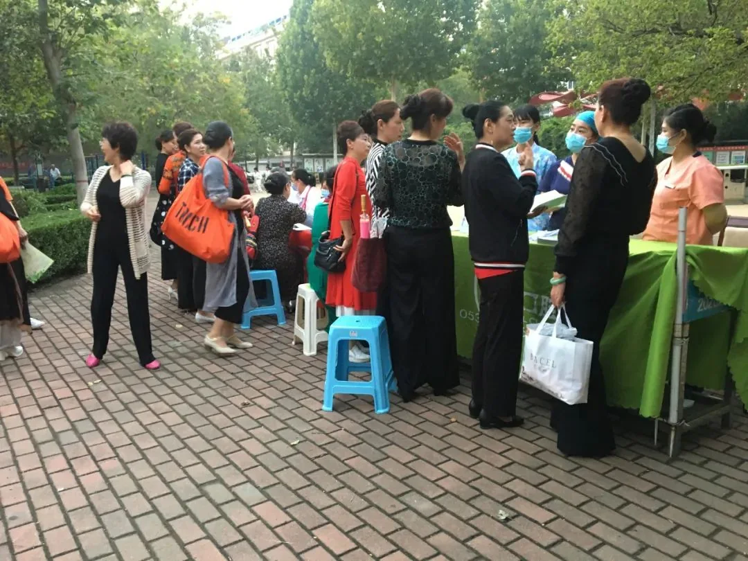 社区居民在公益服务点咨询口腔健康问题。