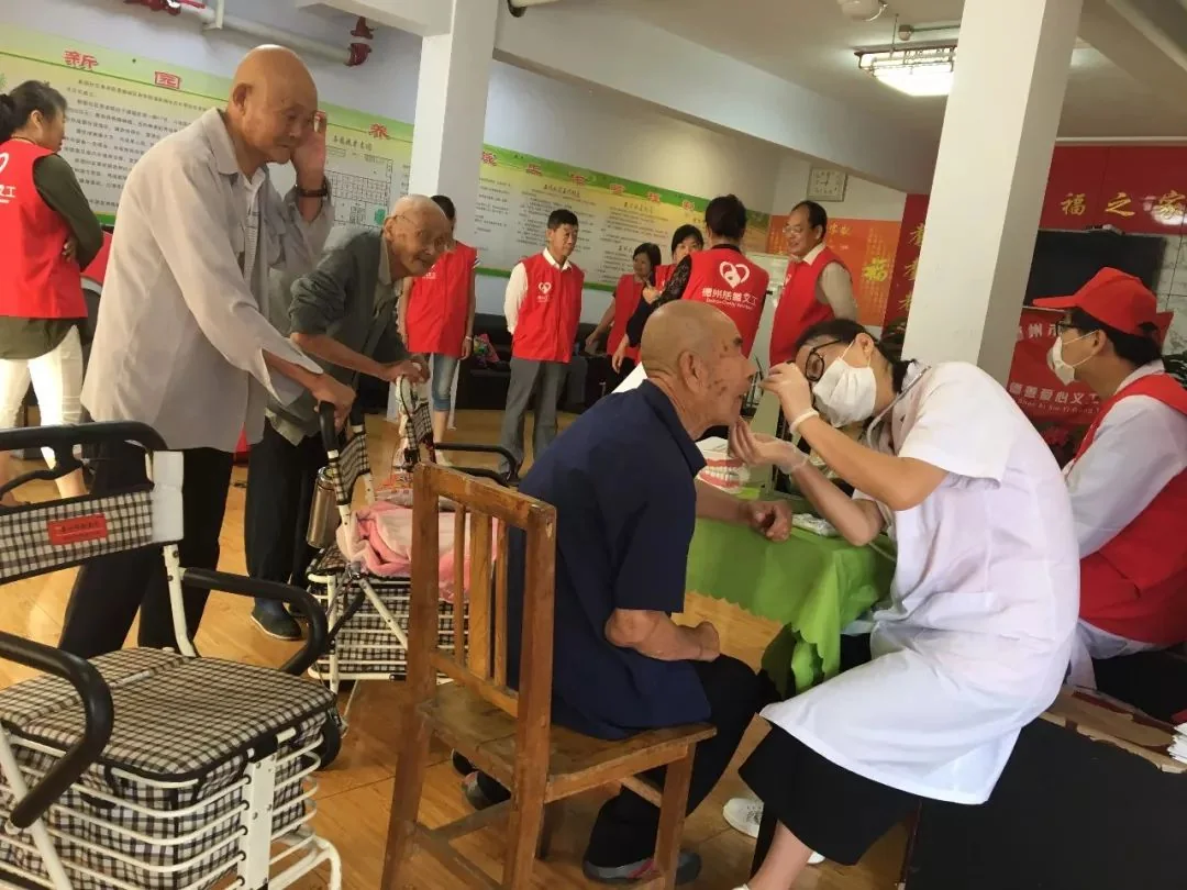 义工人员在养老公寓内为老人进行基础口腔观察。